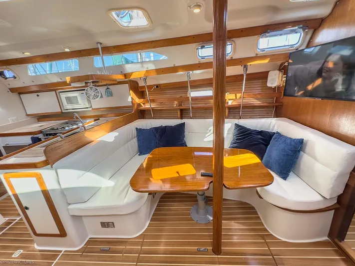 Moondust Yacht Photos Pics Interior of a 1997 Catalina 380 yacht with wooden table and white seating.