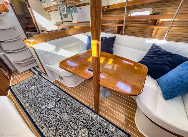 Moondust Yacht Photos Pics Interior of a 1997 Catalina 380 yacht with wooden table and white seating.
