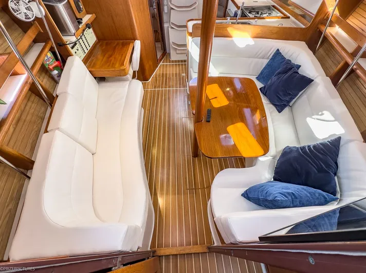 Moondust Yacht Photos Pics Interior of a 1997 Catalina 380 yacht with white sofas and wooden table.