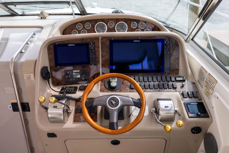  Yacht Photos Pics Cockpit of 2000 Sea Ray 370 Express Cruiser with navigation equipment and wooden steering wheel.