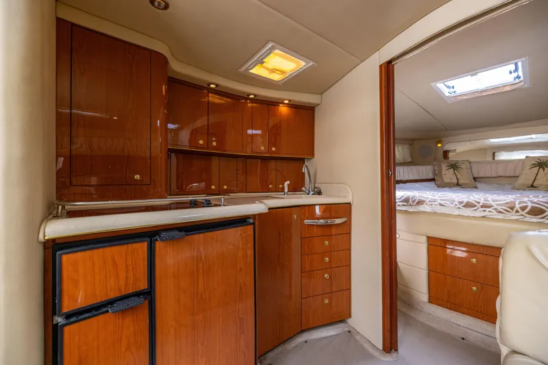  Yacht Photos Pics Interior of 2000 Sea Ray 370 Express Cruiser with wood cabinetry and cozy sleeping area.