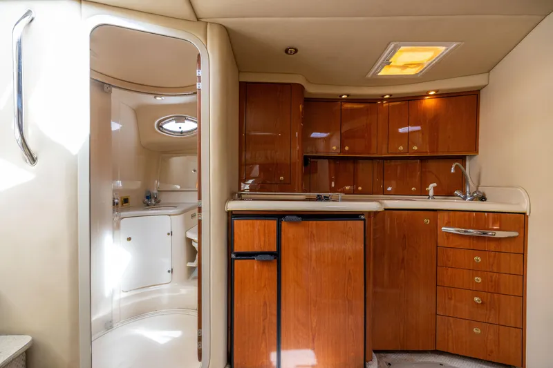  Yacht Photos Pics Interior of 2000 Sea Ray 370 Express Cruiser with wooden cabinets and compact kitchen area.