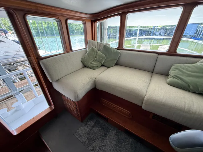 Passage Yacht Photos Pics Cozy interior of a 2009 Custom Dutch Canal Barge with cushioned seating and large windows.