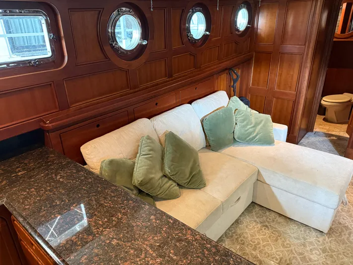 Passage Yacht Photos Pics Luxurious interior of a 2009 Custom Dutch Canal Barge with plush seating and wooden paneling.