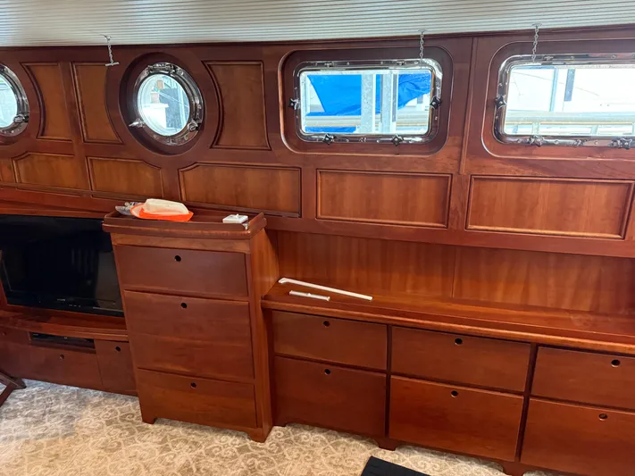 Passage Yacht Photos Pics Interior of a 2009 custom Dutch canal barge with wooden cabinetry and porthole windows.