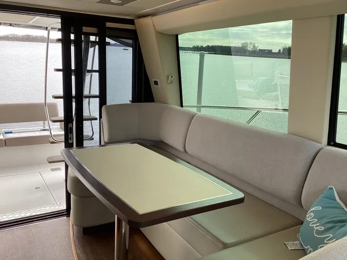  Yacht Photos Pics Interior of 2018 Regal 42 Fly yacht with elegant seating and table by large windows.