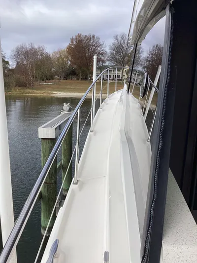  Yacht Photos Pics Side view of 2018 Regal 42 Fly yacht docked by a calm waterfront.