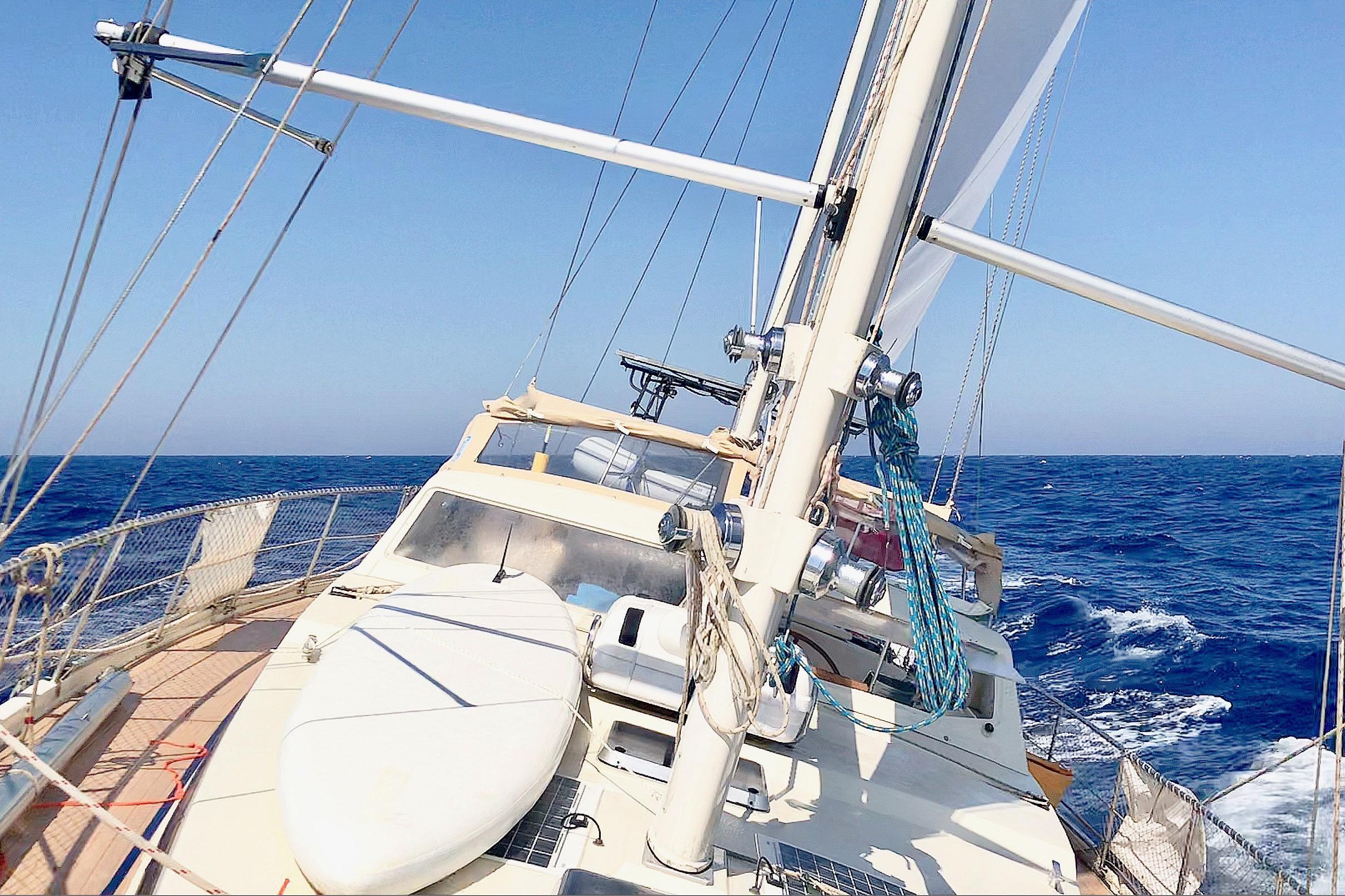 Sailing yacht Amel Super Maramu 1997 navigating open sea under clear blue sky.