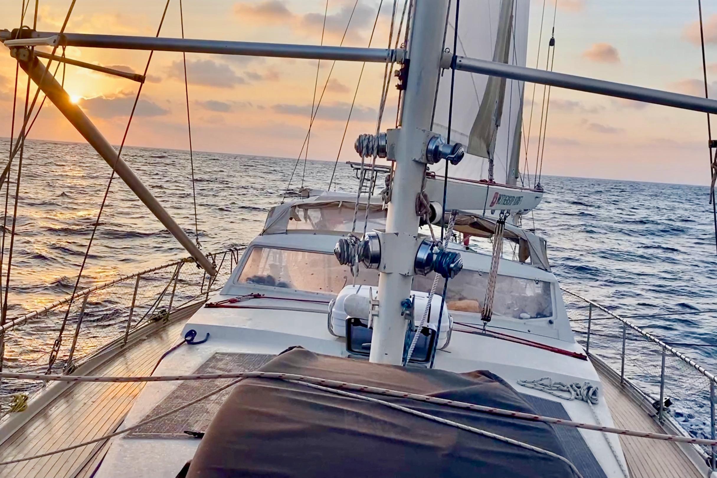 Sailing yacht Amel Super Maramu 1997 at sunset on open sea.