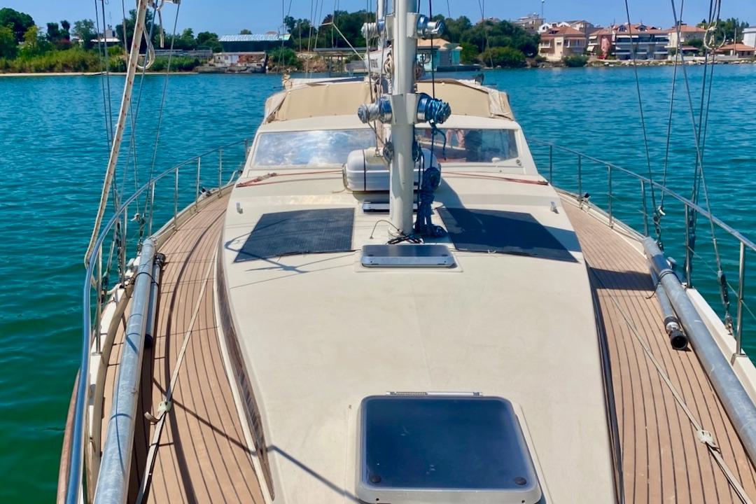 1997 Amel Super Maramu sailboat deck with scenic waterfront view.
