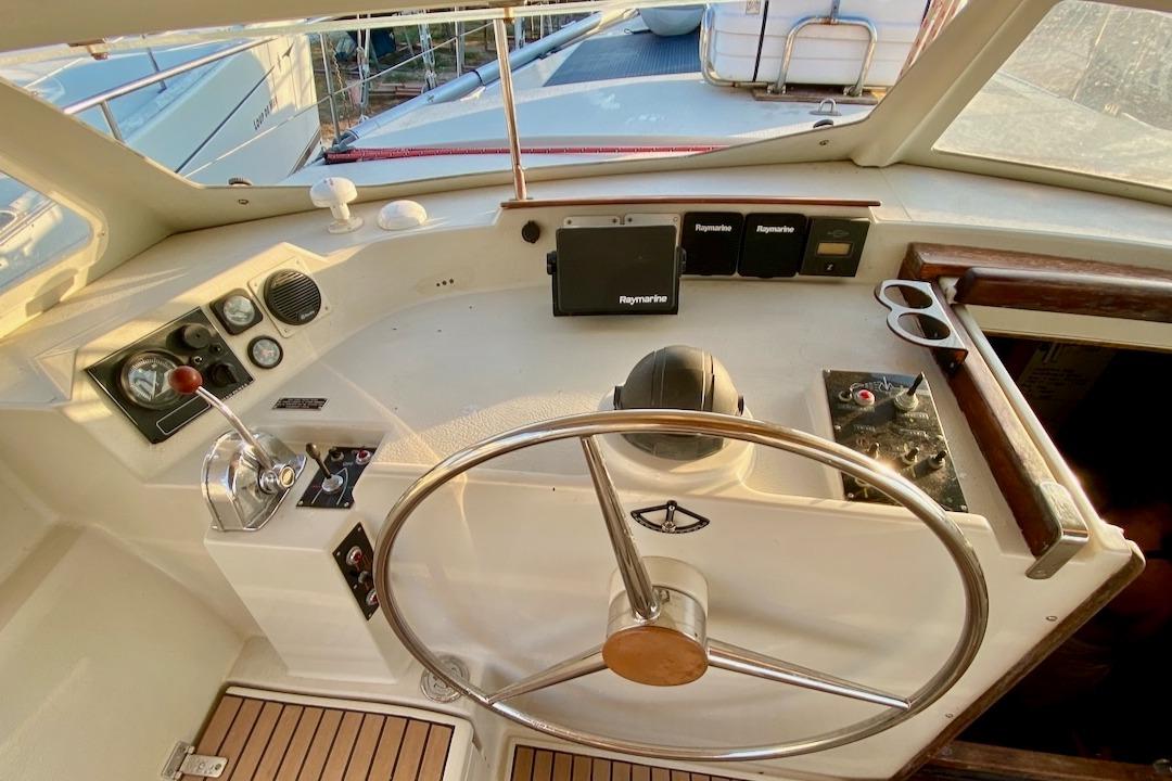 1997 Amel Super Maramu yacht helm with steering wheel and navigation instruments.