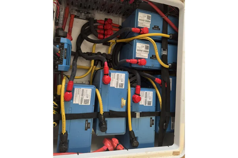 Isthmus Breeze Yacht Photos Pics Battery compartment of a 2023 Bali 4.2, featuring multiple blue batteries and wiring.