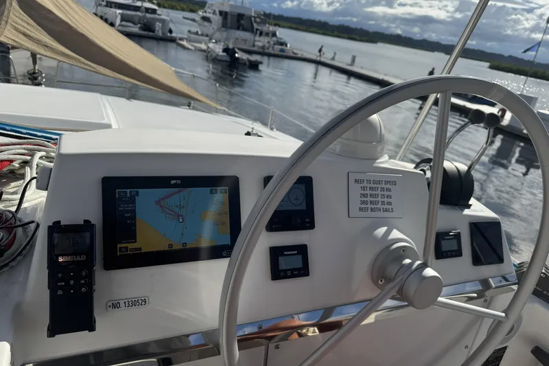 Isthmus Breeze Yacht Photos Pics Helm of 2023 Bali 4.2 catamaran with navigation equipment and steering wheel, docked at marina.