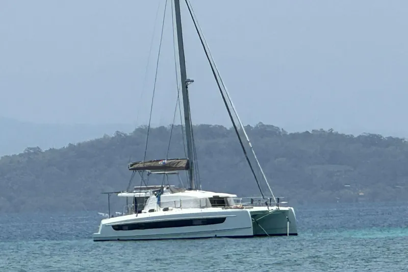 Isthmus Breeze Yacht Photos Pics 2023 Bali 4.2 catamaran anchored in calm waters with scenic mountain backdrop.