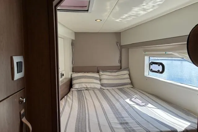 Isthmus Breeze Yacht Photos Pics Cozy bedroom in 2023 Bali 4.2 yacht with striped bedding and window view.