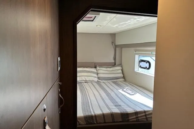 Isthmus Breeze Yacht Photos Pics Cozy bedroom interior in 2023 Bali 4.2 yacht with striped bedding and window.