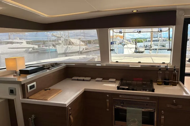 Isthmus Breeze Yacht Photos Pics Modern kitchen interior on a 2023 Bali 4.2 yacht, featuring a stove and marina view.