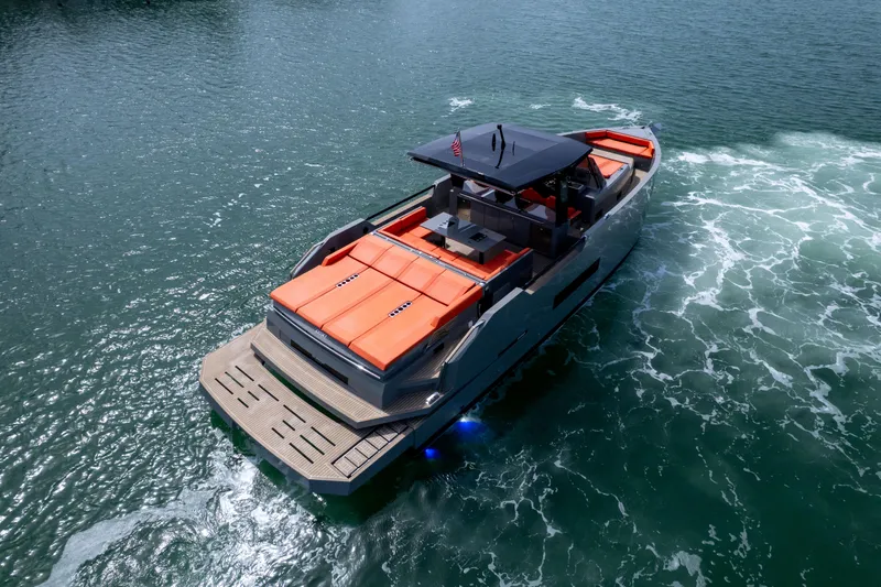  Yacht Photos Pics 2023 De Antonio Yachts D50 cruising on water, featuring sleek design and vibrant orange seating.