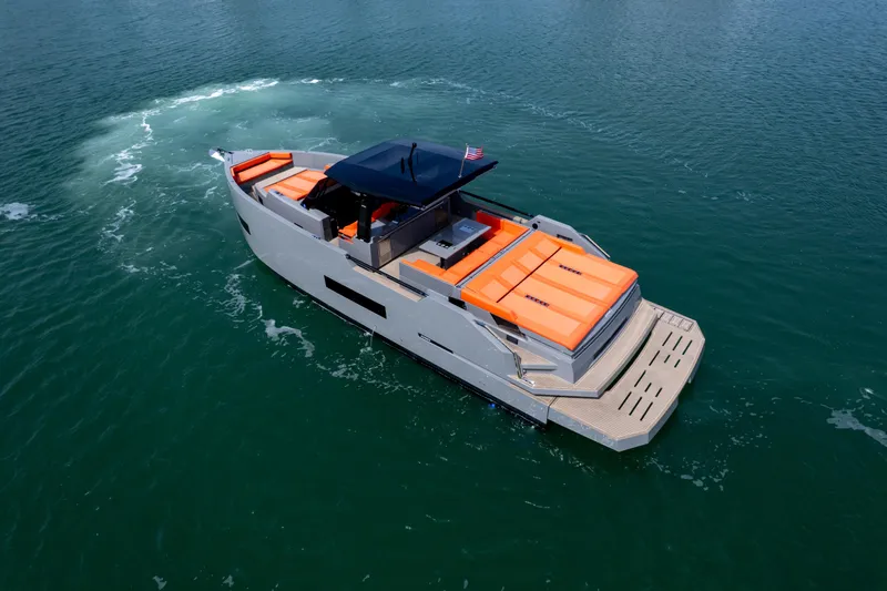  Yacht Photos Pics 2023 De Antonio Yachts D50 cruising on open water with vibrant orange seating.