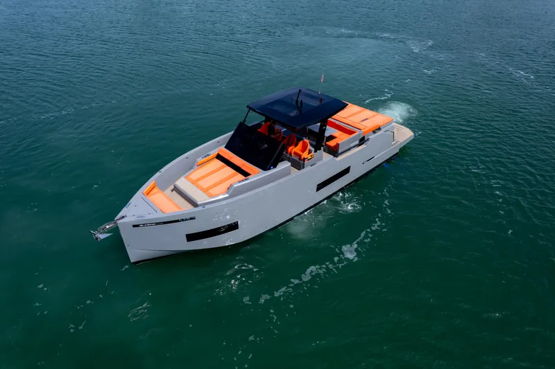  Yacht Photos Pics 2023 De Antonio Yachts D50 cruising on open water, featuring sleek design and vibrant orange seating.