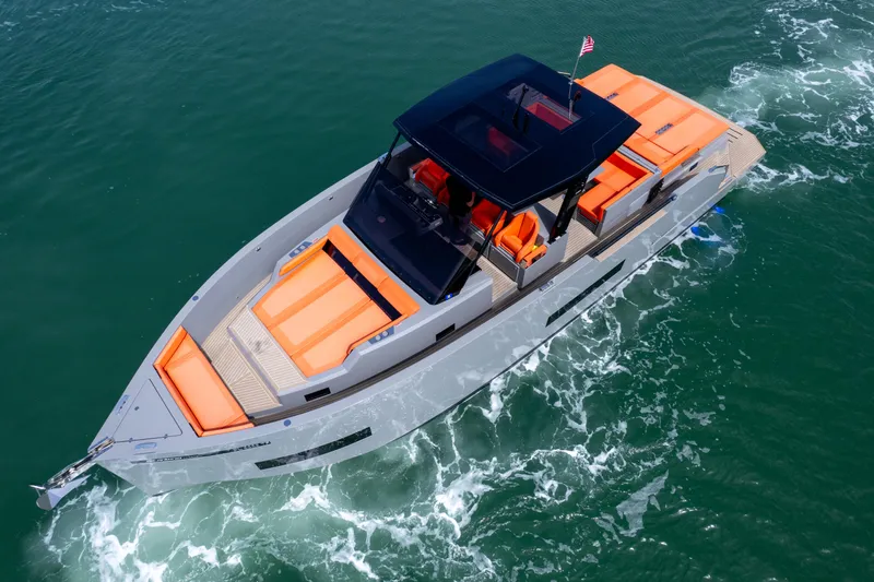  Yacht Photos Pics 2023 De Antonio Yachts D50 cruising on water, featuring sleek design and vibrant orange seating.