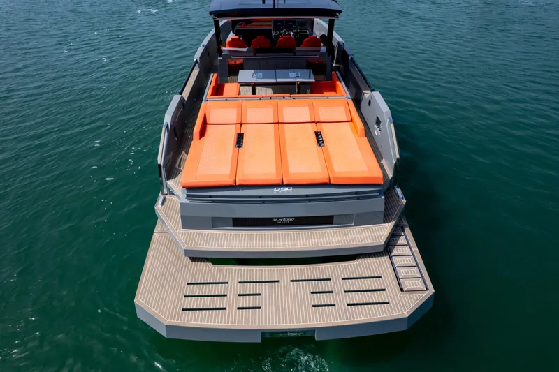  Yacht Photos Pics 2023 De Antonio Yachts D50 with orange sunbeds, sleek design, and spacious deck on the water.