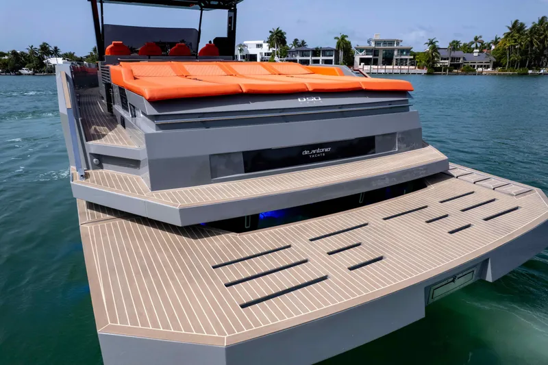 Yacht Photos Pics 2023 De Antonio Yachts D50 with orange seating, docked on calm water.