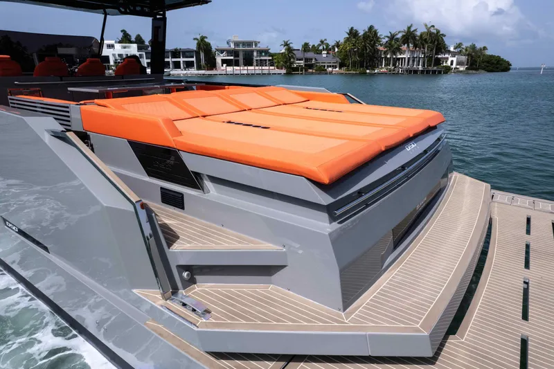  Yacht Photos Pics 2023 De Antonio Yachts D50 with orange sunbeds, docked near luxury waterfront homes.