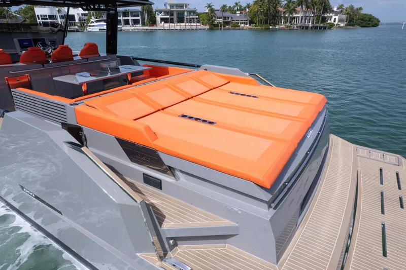  Yacht Photos Pics 2023 De Antonio Yachts D50 with orange sunbeds, docked by waterfront homes.