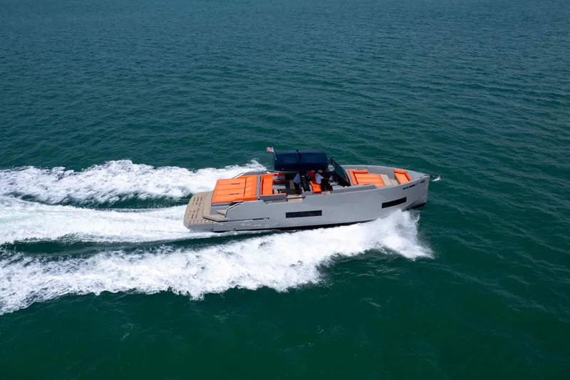  Yacht Photos Pics 2023 De Antonio Yachts D50 cruising on open water, showcasing sleek design and vibrant accents.