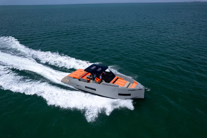  Yacht Photos Pics 2023 De Antonio Yachts D50 cruising on open water, featuring sleek design and vibrant orange seating.