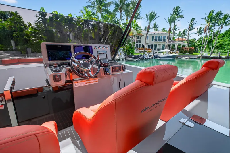  Yacht Photos Pics 2023 De Antonio Yachts D50 helm with red seats, modern controls, and waterfront view.