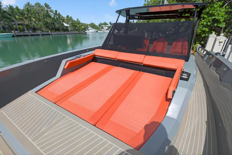  Yacht Photos Pics 2023 De Antonio Yachts D50 with orange seating, docked by lush greenery.