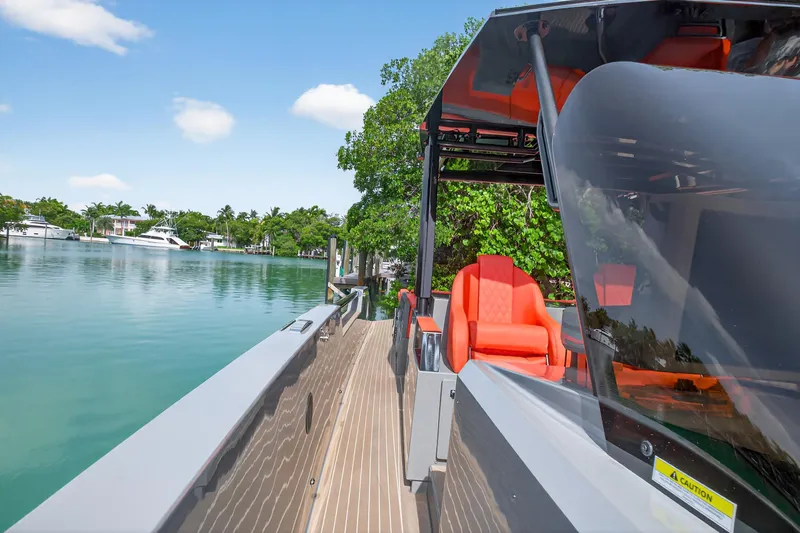  Yacht Photos Pics 2023 De Antonio Yachts D50 with vibrant orange seating, docked by a serene waterfront.