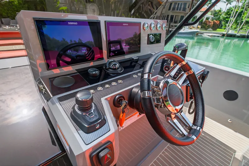  Yacht Photos Pics 2023 De Antonio Yachts D50 helm with dual Simrad displays and sleek steering wheel.