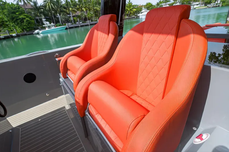  Yacht Photos Pics Luxurious orange seats on 2023 De Antonio Yachts D50, docked by a serene waterfront.