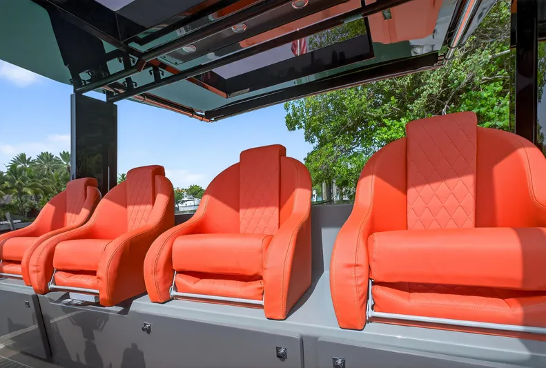  Yacht Photos Pics Luxurious orange seats on 2023 De Antonio Yachts D50, under sleek canopy, surrounded by greenery.
