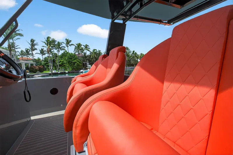  Yacht Photos Pics 2023 De Antonio Yachts D50 with vibrant orange seats, luxurious design, and scenic waterfront view.