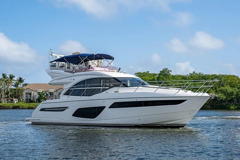  Yacht Photos Pics 2022 Princess F50 yacht cruising on a serene waterway under a clear blue sky.