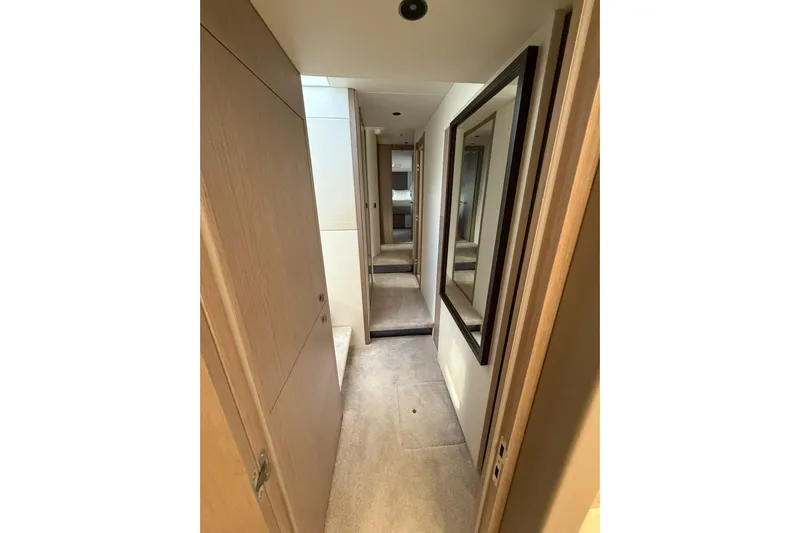 Svetlana Yacht Photos Pics Narrow hallway inside 2025 Sunseeker 76 Yacht, featuring modern wood paneling and mirrors.