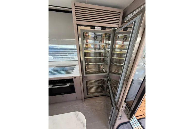 Svetlana Yacht Photos Pics Modern kitchen interior on 2025 Sunseeker 76 Yacht with open stainless steel fridge.