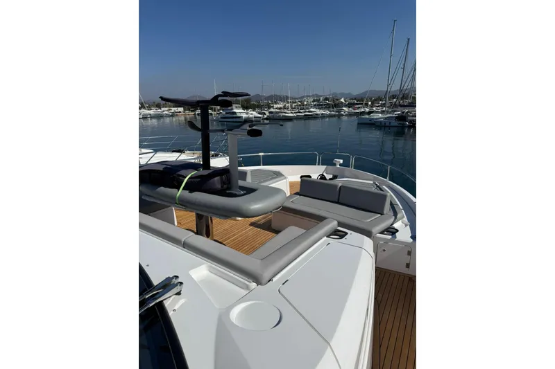 Svetlana Yacht Photos Pics 2025 Sunseeker 76 Yacht deck with seating and watercraft, docked in marina.