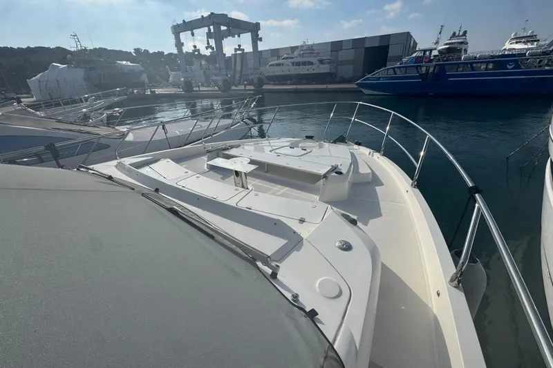  Yacht Photos Pics 2023 Absolute 52 FLY yacht docked at marina, showcasing sleek design and spacious deck.