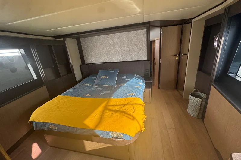  Yacht Photos Pics Luxurious bedroom interior of 2023 Absolute 52 FLY yacht with modern design and cozy bedding.