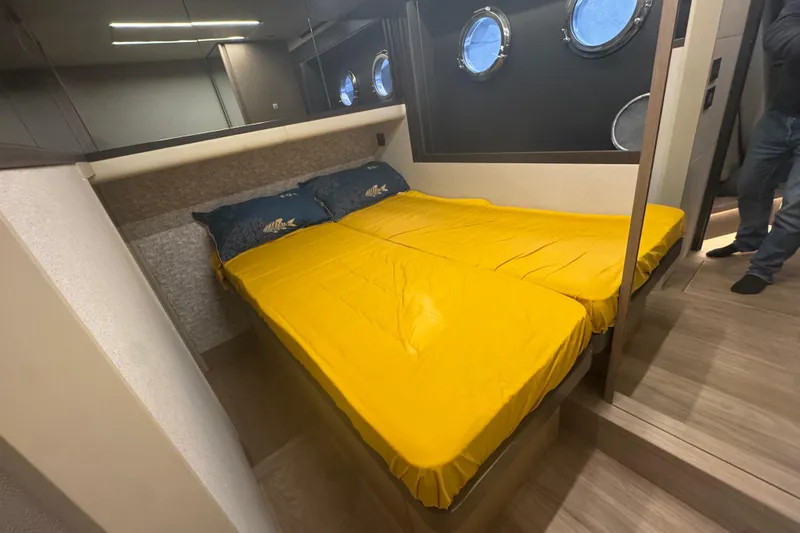  Yacht Photos Pics Cozy bedroom in 2023 Absolute 52 FLY yacht with yellow bedding and porthole windows.