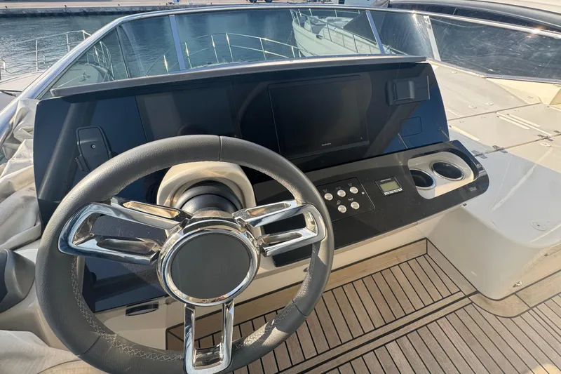  Yacht Photos Pics Steering wheel and dashboard of 2023 Absolute 52 FLY yacht, featuring modern controls.