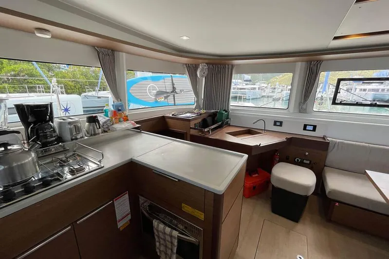 Sand Dollar Yacht Photos Pics Modern kitchen interior of 2023 Lagoon 46 yacht with appliances and seating area.
