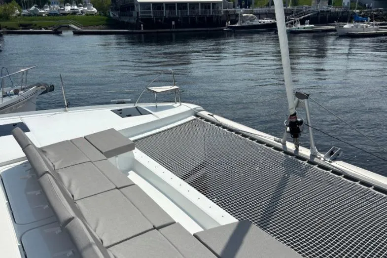 White Cap IV Yacht Photos Pics 2024 Fountaine Pajot Astrea 42 catamaran with spacious deck and netting, docked at marina.