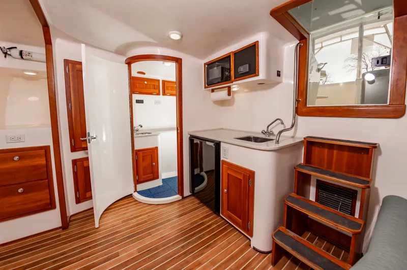 Carry On Yacht Photos Pics Interior of 2003 Custom Carolina Layton Express with wood flooring and kitchenette.