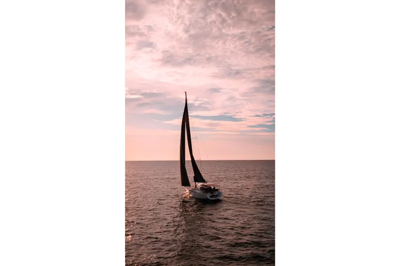  Yacht Photos Pics Sailing yacht Beneteau Oceanis 58, 2013 model, on tranquil sea at sunset.